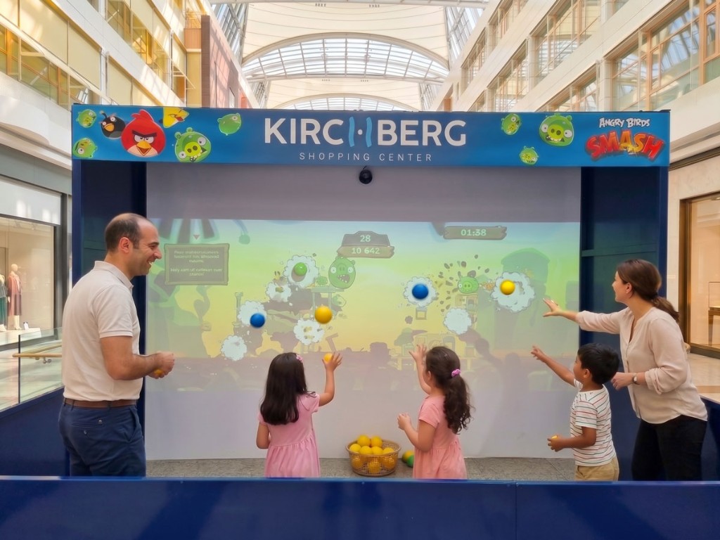 Famille jouant à Angry Birds Smash sur un mur interactif immersif